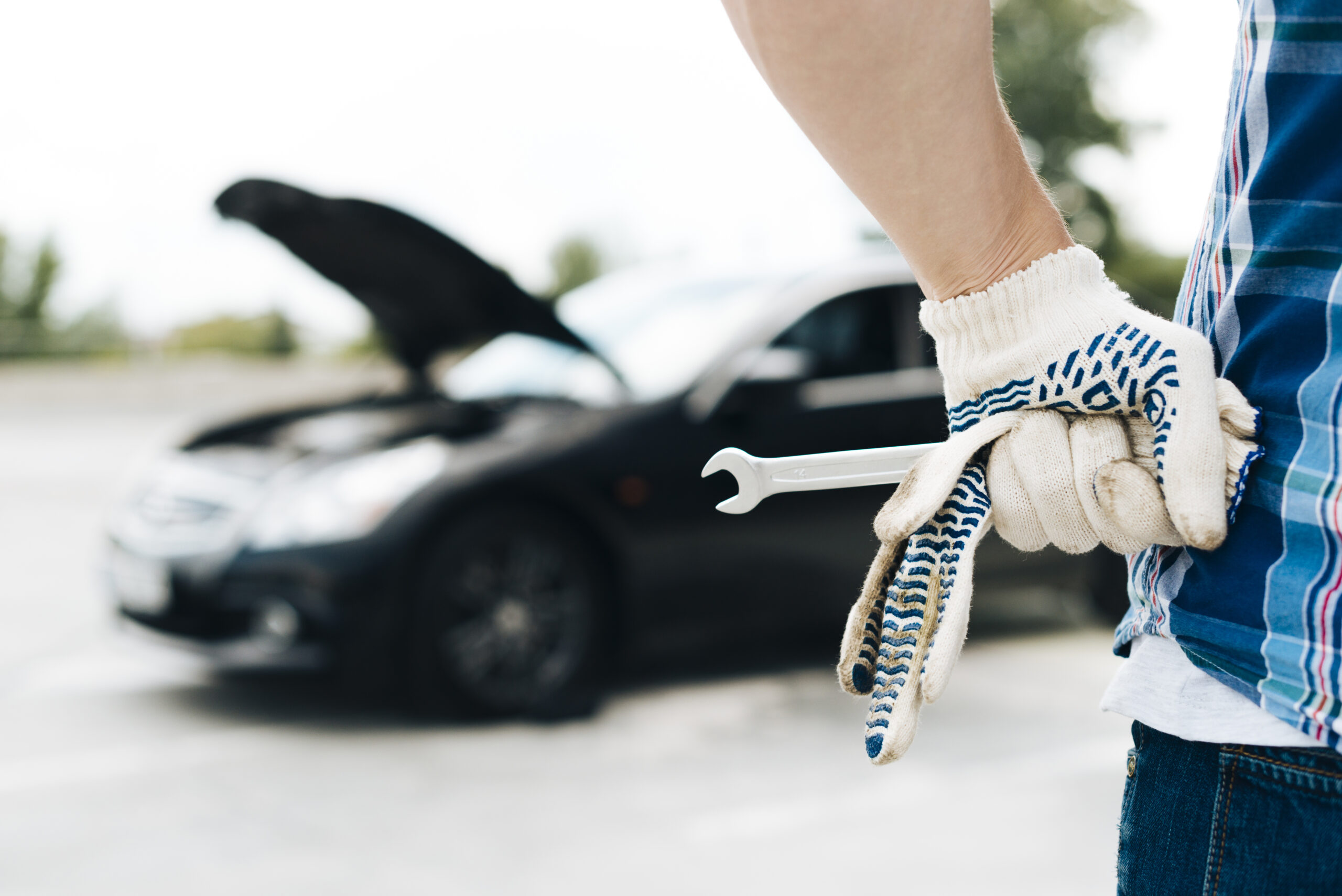 man-wearing-gloves-holding-wrench